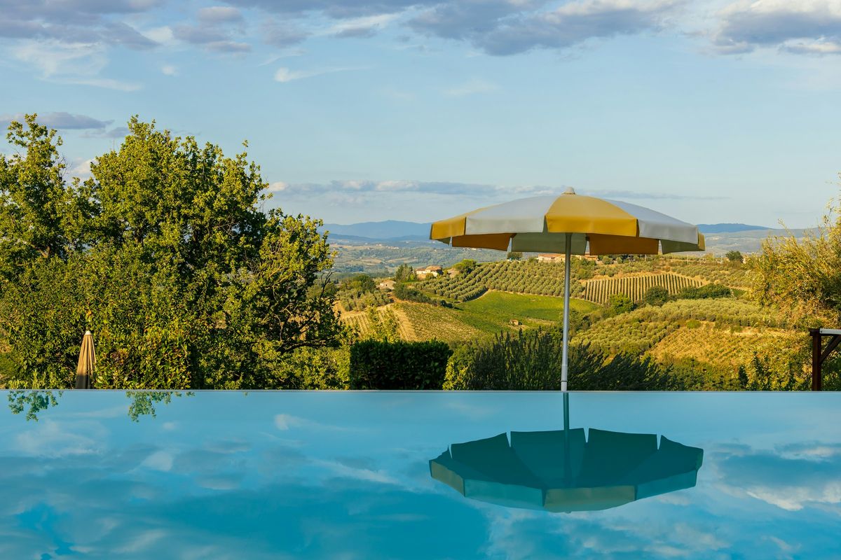 Piscina con ombrellone e vigneti